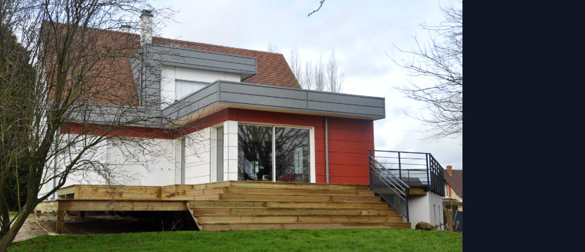 Une terrasse en bois courant le long des pièces à vivre dans la région de Rouen